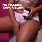 Person holding a supplement bottle with 'No Fillers. 100% Vegan.' text on a pink background