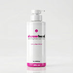 White bottle of 'showerhead' body wash scrub with pink accents on a light gray background