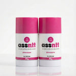 Two containers of 'assnnt' all natural intimate deodorant with pink caps on a white background.